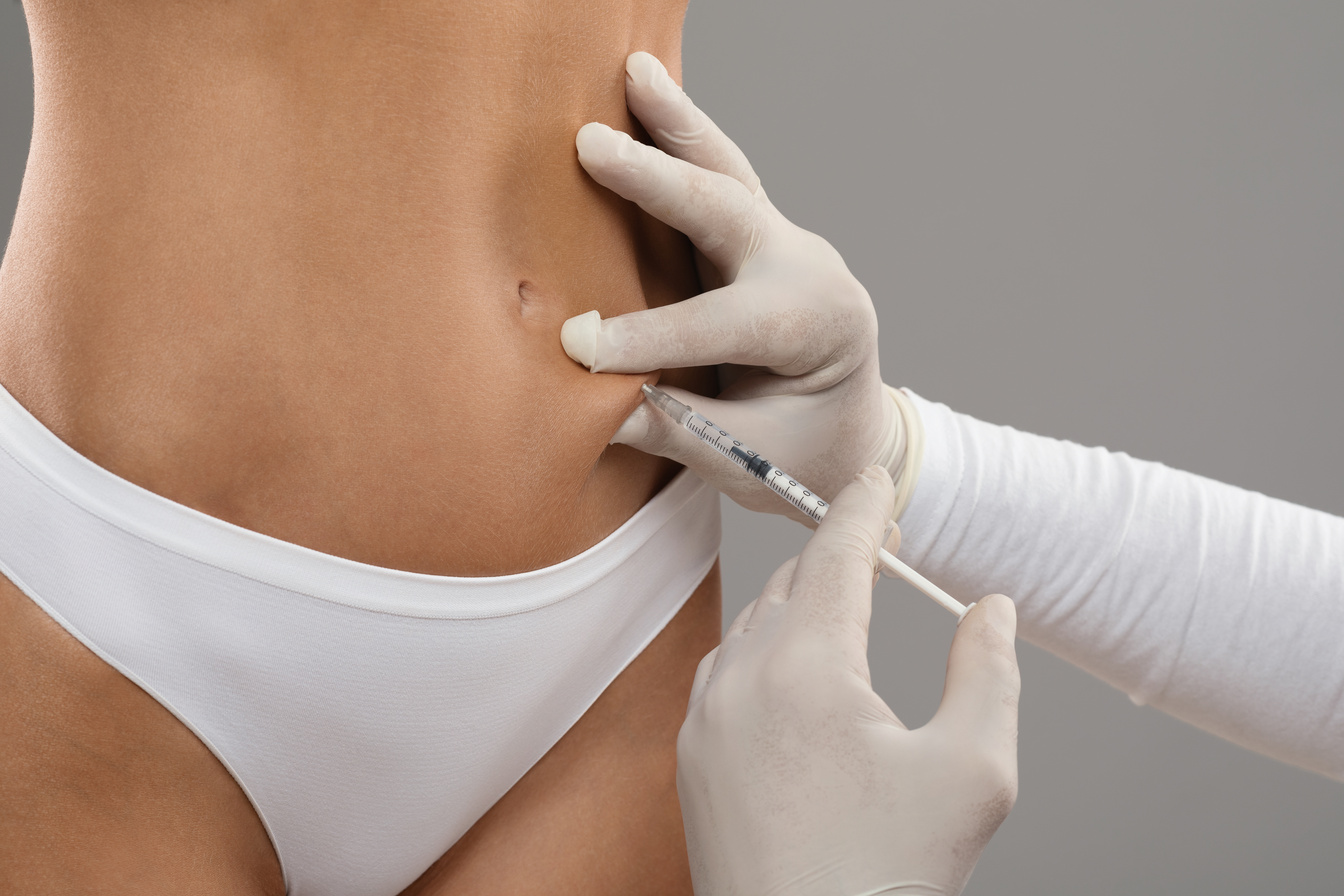 Lipolysis Concept. Beautician Doctor Making Injection With Syrringe To Female Patient Belly